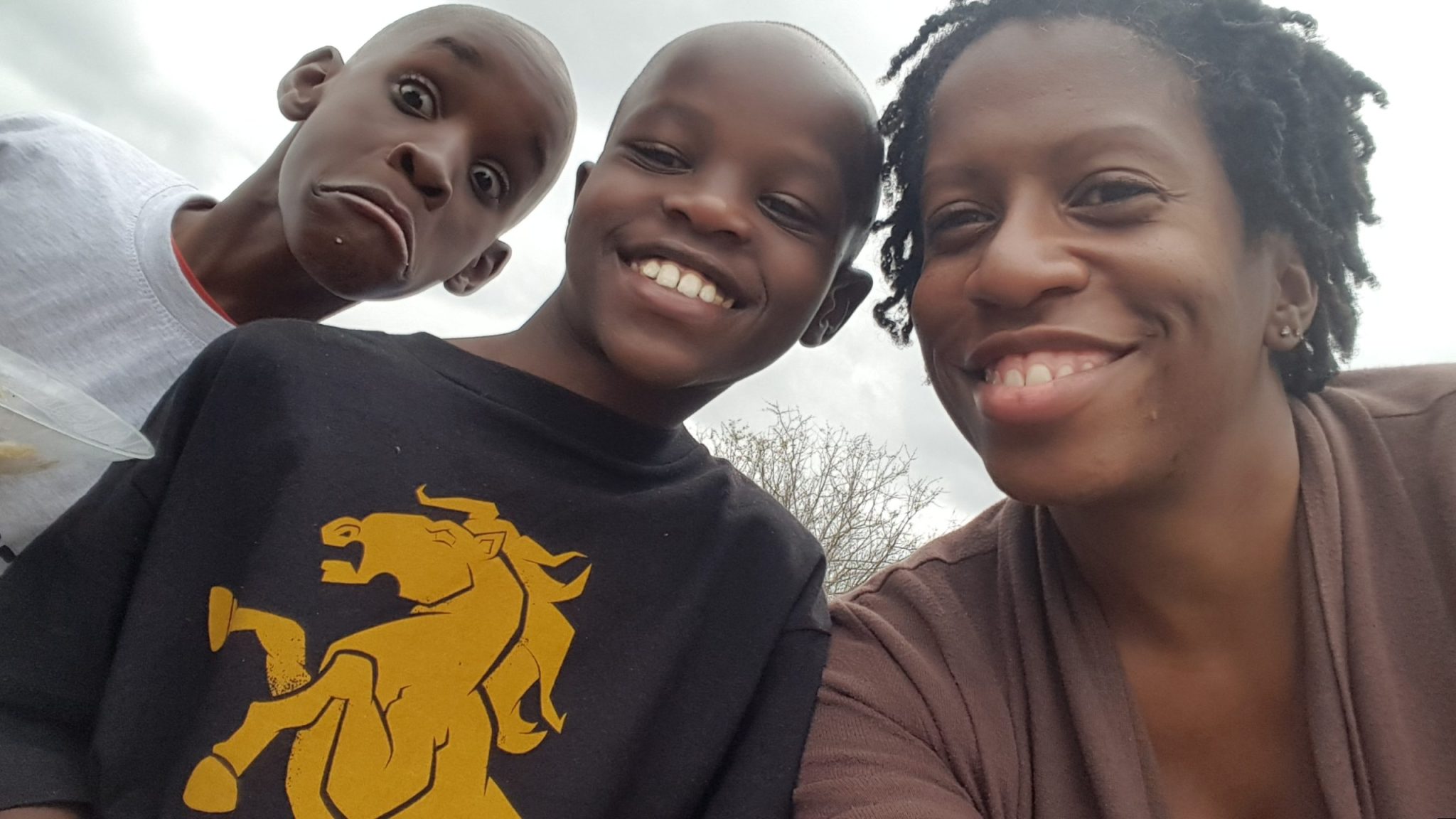 Kennesha smiling with Henry and another boy during the 2018 Mission to Kenya at Happy Life in Juja Farm.
