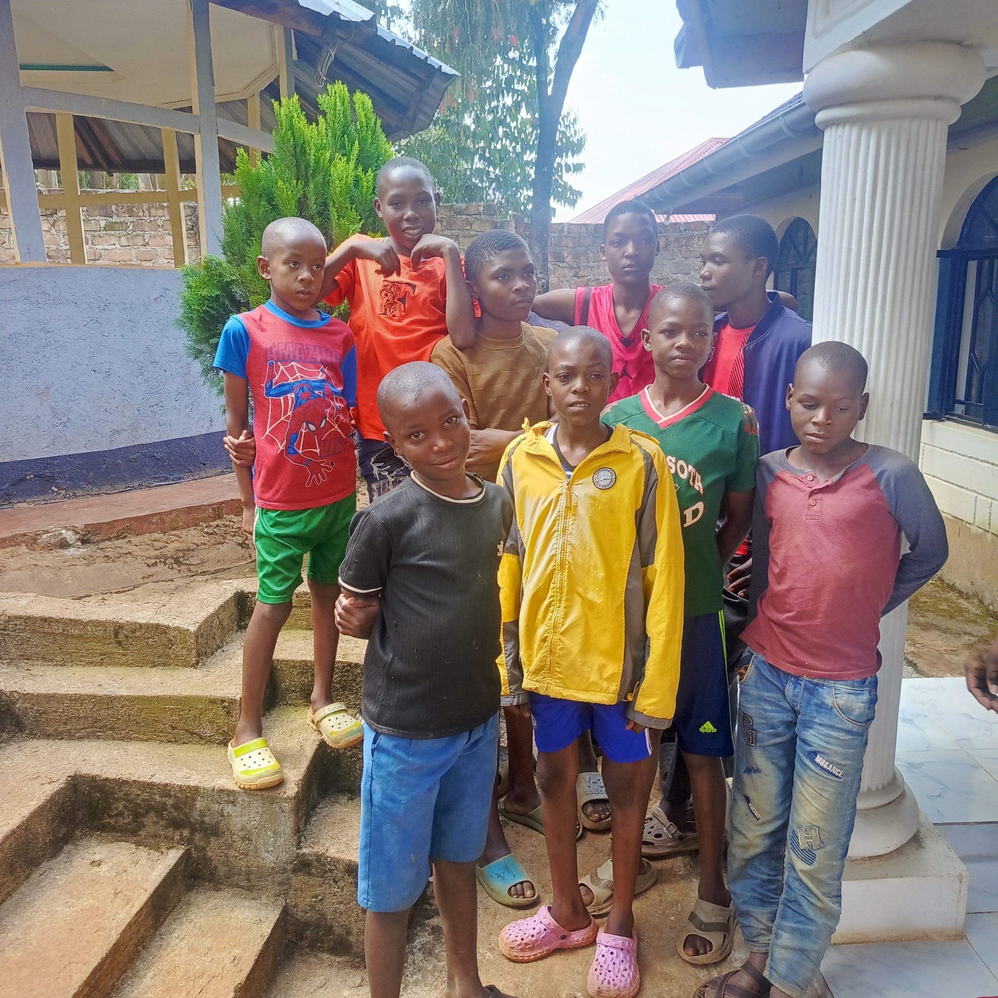Boys standing together outside a home.